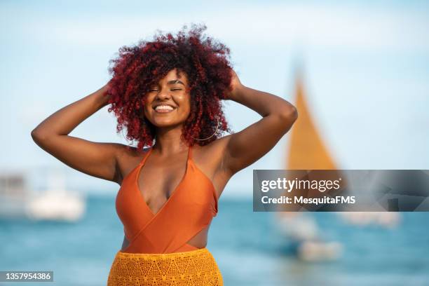 mujer afro con las manos en el pelo - traje de baño de una pieza fotografías e imágenes de stock