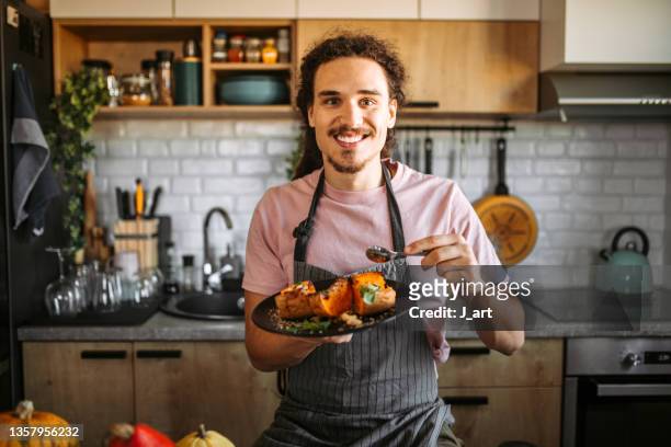 young man eating delicious and healthy dessert, pumpkin with honey and cinnamon. - portrait cuisine stock-fotos und bilder