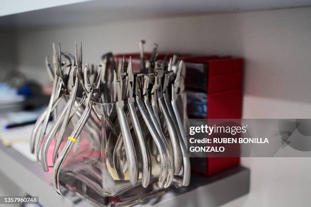 row of dental pliers in a glass box at a dentist´s office on white background - dentist's surgery stock pictures, royalty-free photos & images