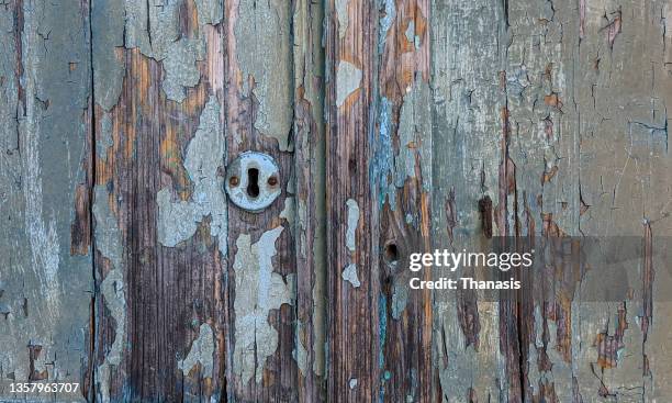 close-up of keyhole on a weathered wooden doorway - broken door stock-fotos und bilder