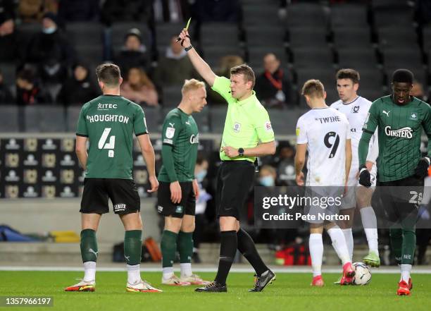 Jordan Houghton of Plymouth Argyle is shown a yellow card by referee Samuel Barrott during the Sky Bet League One match between Milton Keynes Dons...