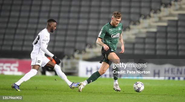 Dan Scarr of Plymouth Argyle moves with the ball away from Mo Eisa of Milton Keynes Dons during the Sky Bet League One match between Milton Keynes...