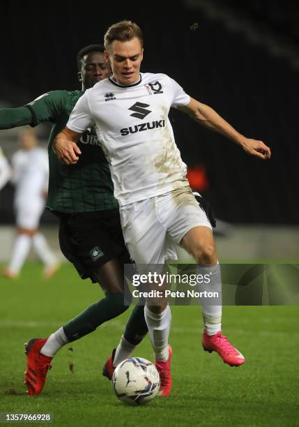 Scott Twine of Milton Keynes Dons moves with the ball under pressure from Jordan Garrick of Plymouth Argyle during the Sky Bet League One match...