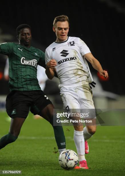 Scott Twine of Milton Keynes Dons moves with the ball under pressure from Jordan Garrick of Plymouth Argyle during the Sky Bet League One match...