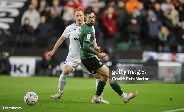 Dean Lewington of Milton Keynes Dons and Ryan Hardie of Plymouth Argyle look to the ball during the Sky Bet League One match between Milton Keynes...