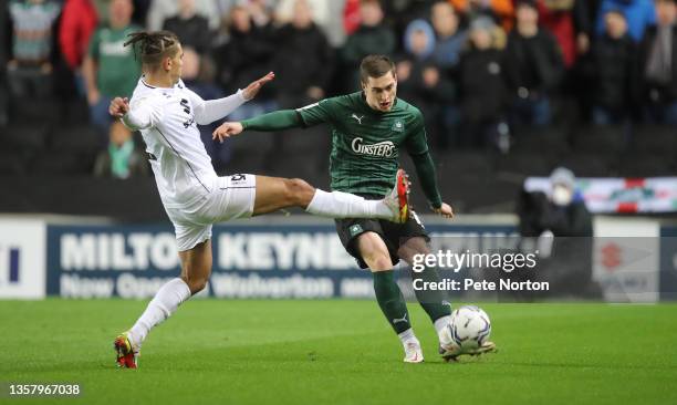 Conor Grant of Plymouth Argyle look to play the ball past Tennai Watson of Milton Keynes Dons during the Sky Bet League One match between Milton...