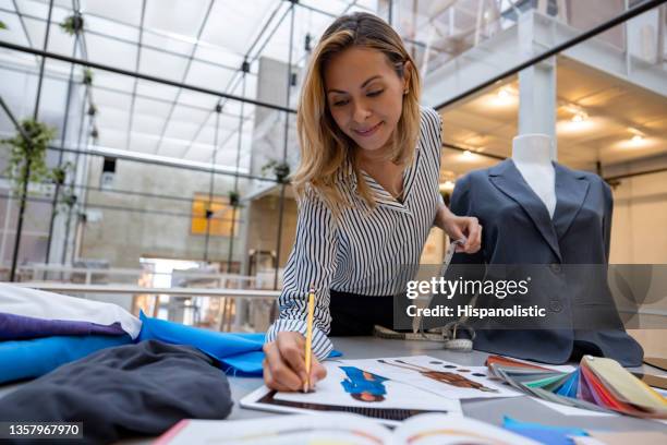modedesignerin skizziert ein design in ihrem atelier - textilfabrik stock-fotos und bilder