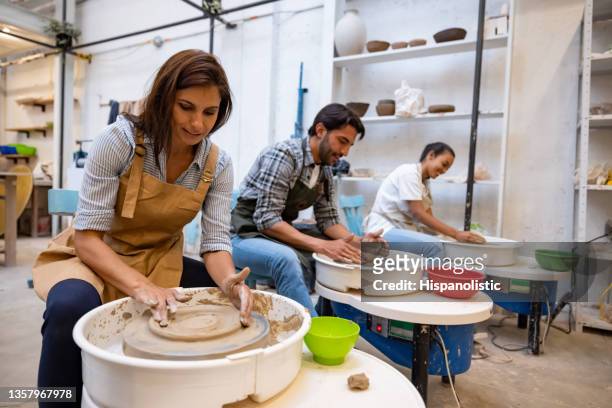 happy group of people in a pottery class - potters wheel stock pictures, royalty-free photos & images