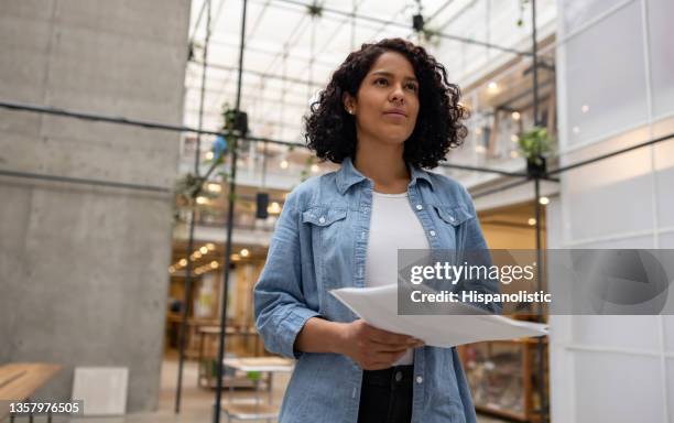 mujer de negocios que trabaja en la oficina y sostiene algunos documentos - curriculum vitae fotografías e imágenes de stock