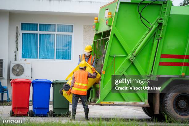 garbage removal man loading waste and trash bin. - industrial garbage bin stock pictures, royalty-free photos & images