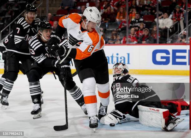 Travis Sanheim of the Philadelphia Flyers is unable to get the puck past Mackenzie Blackwood of the New Jersey Devils as Ryan Graves and Dougie...