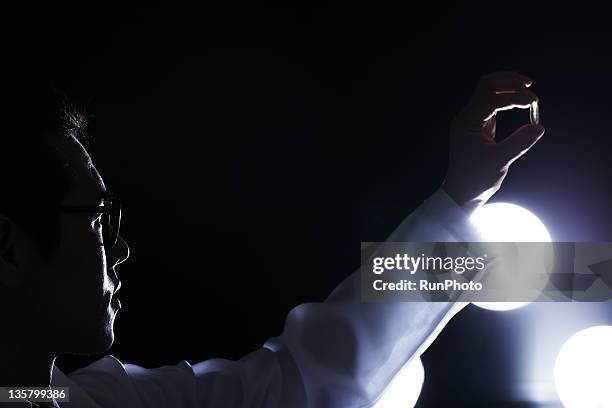 doctor looking at the medicine - dark background light stock-fotos und bilder