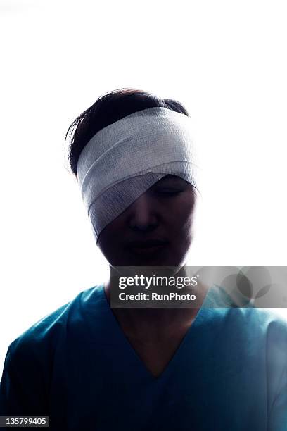 patient with a bandage wrapped around the head - head bandage stock-fotos und bilder