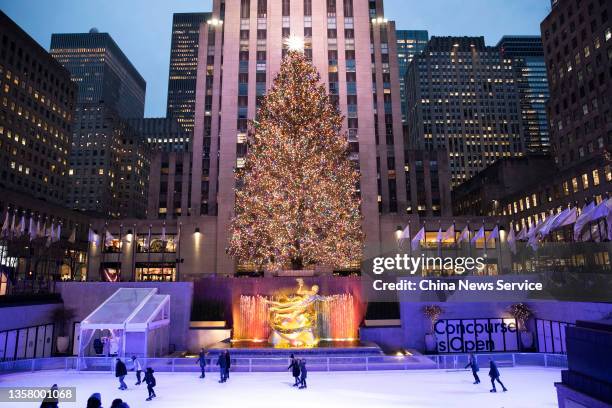 People skate in front of the illuminated Christmas tree at Rockefeller Center on December 8, 2021 in New York.