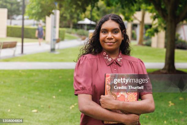 female aboriginal australian student holding laptop - inheemse bevolking stockfoto's en -beelden