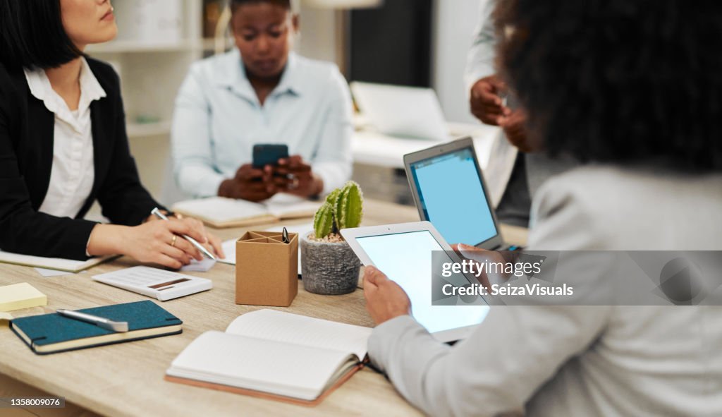 Primer plano de una mujer de negocios irreconocible que usa una tableta digital con una pantalla en blanco durante una reunión en una oficina