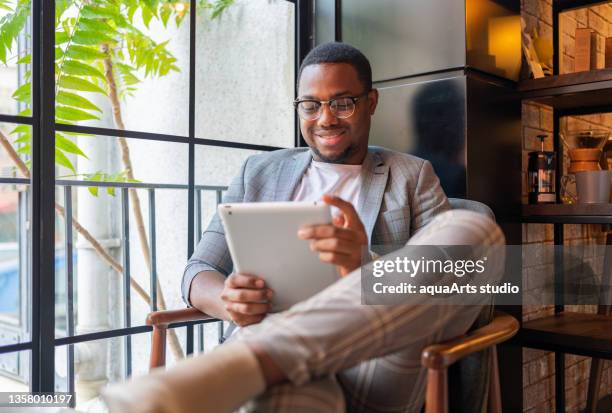 male freelancer at coffee shop - reading ipad stock pictures, royalty-free photos & images