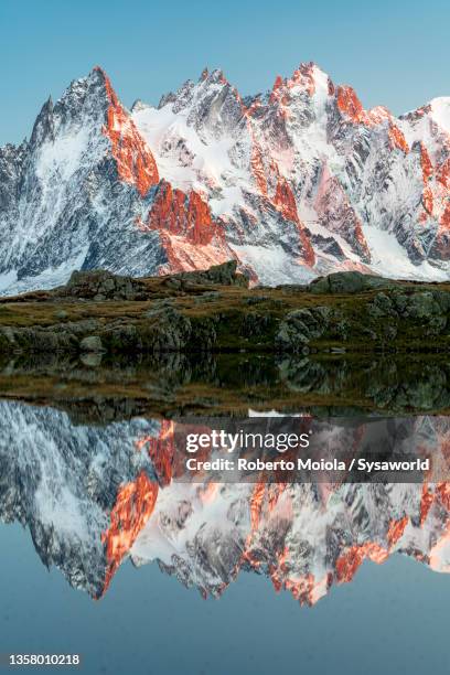 mont blanc massif reflected in water at sunset, france - lake chesery stockfoto's en -beelden