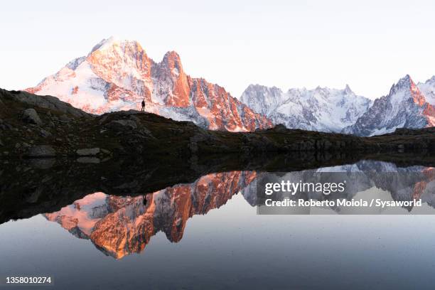 person admiring mountains from lake chesery, france - lake chesery stockfoto's en -beelden