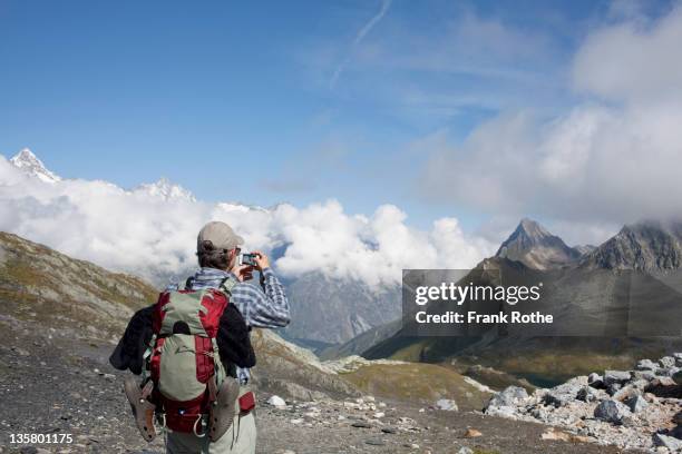 taking a picture on top of the mountain with phone - newoutdoors stock pictures, royalty-free photos & images