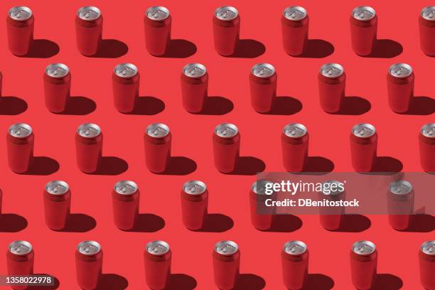 red soda cans pattern with hard shadow on red background. - pop cans stock pictures, royalty-free photos & images