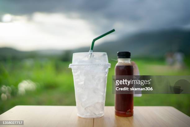 ice green tea with plastic take away cup with plastic stroll and plastic bottle - cold drink ストックフォトと画像