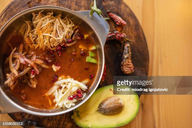 exotic mexican broth, served on the wooden plate with avocado and chili pepper on the side - chicken stew stock pictures, royalty-free photos & images