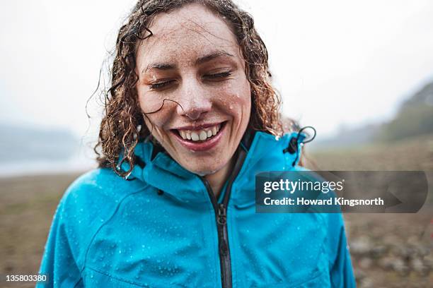 femalesmiling in the rain - mouillé photos et images de collection