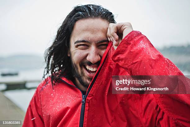 man laughing in the rain, portrait - regnkläder bildbanksfoton och bilder