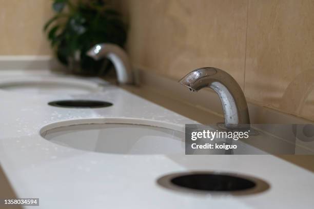 automatic sensor faucet in bathroom - automatic faucet stock pictures, royalty-free photos & images