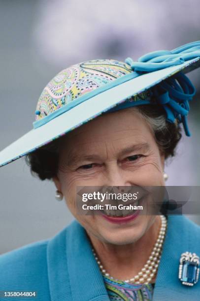 British Royal Queen Elizabeth II, wearing a blue coat with a matching hat, on the quayside at Aberdeen, Aberdeenshire, Scotland, 8th August 1989. The...