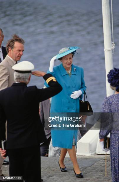 British Royal Queen Elizabeth II, wearing a blue coat with a matching hat, on the quayside at Aberdeen, Aberdeenshire, Scotland, 8th August 1989. The...