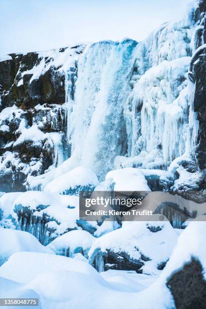 öxarárfoss waterfall in thingvellir national park - frozen waterfall stockfoto's en -beelden