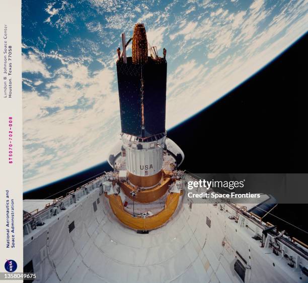 The Tracking and Data Relay Satellite leaves the payload bay of the Space Shuttle Discovery during shuttle mission STS-70, 13th July to 22nd July...