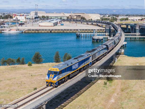 aerial view loaded ora grain train crossing port river bridge - crossed stock pictures, royalty-free photos & images