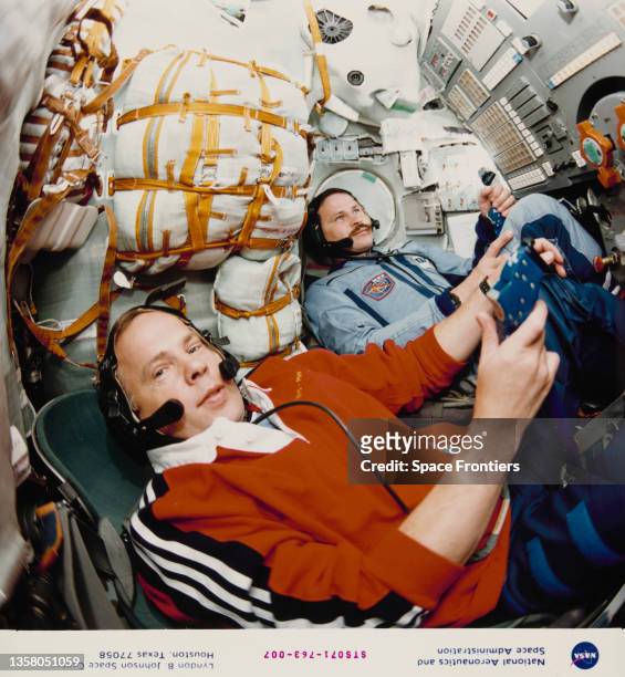 Russian cosmonaut Nikolai Budarin and Latvian-born Russian cosmonaut Anatoly Solovyev in the aft flight deck of the Space Shuttle Atlantis as the...