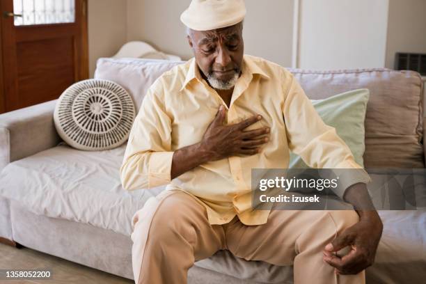 anciano con dolor en el pecho en casa - cardiopatía fotografías e imágenes de stock