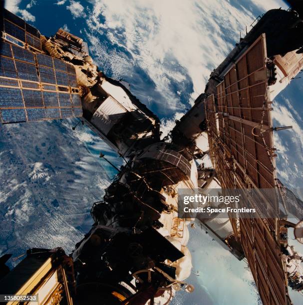 Russian Space Station Mir, with Cape Canaveral and the Kennedy Space Center visible below one of the solar panels, against a backdrop of the southern...