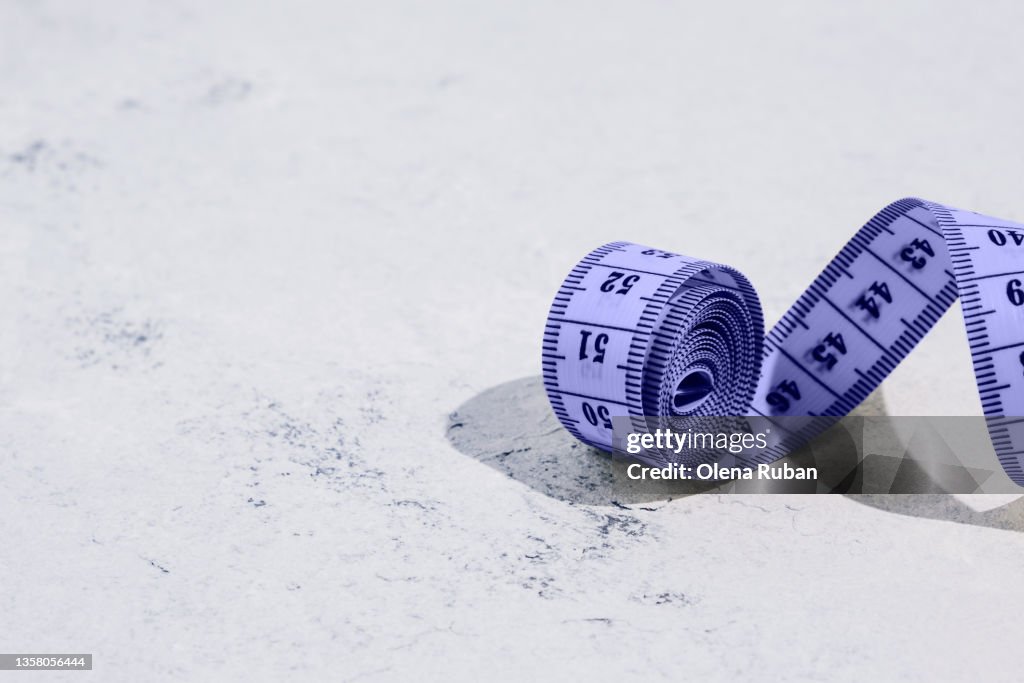 Purple measuring tape on white background
