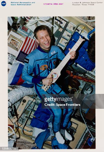 German ESA astronaut Thomas Reiter with a collapsible guitar, a gift for the Mir crew from the STS-74 crew, in the core module of Mira during Space...