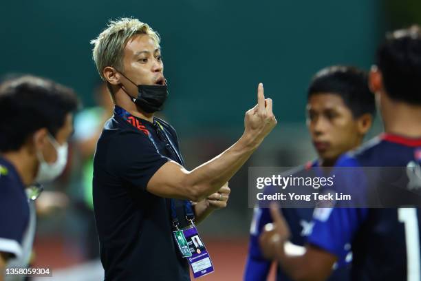 General manager and head coach Keisuke Honda of Cambodia instructs his players from the sidelines prior to the AFF Suzuki Cup Group B game against...