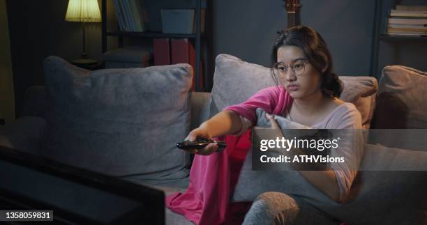 teenager boring while watching tv at home in the night time. - girl lying down stock pictures, royalty-free photos & images