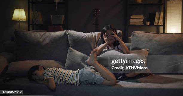 sibling sister and brother watching scare movie in the living room at home - family watching television stock pictures, royalty-free photos & images