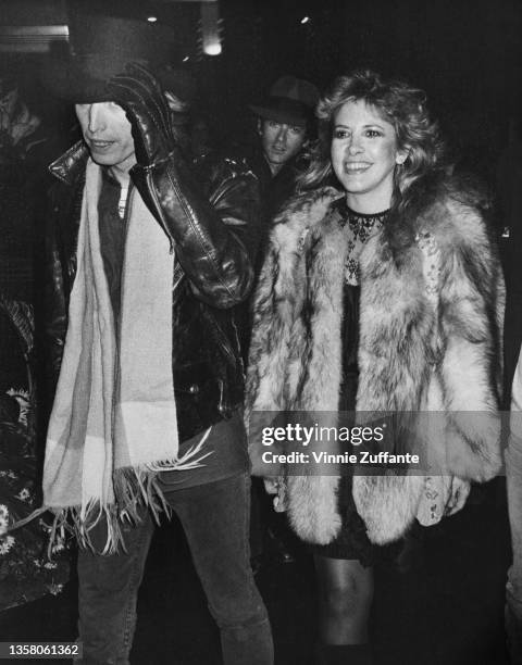 American singer, songwriter and musician Tom Petty , wearing a top hat with a black leather jacket, black gloves and a scarf, with American singer...