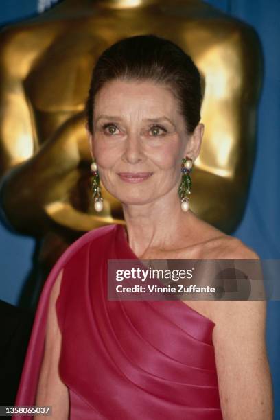 British actress Audrey Hepburn , wearing an asymmetrical fuchsia pink evening gown, in the press room of the 64th Academy Awards, held at the Dorothy...