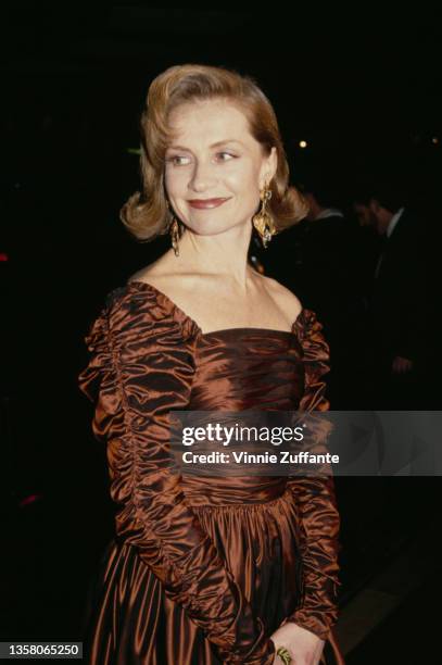 French actress Isabelle Huppert, wearing a bronze-coloured evening gown, attends the 49th Golden Globe Awards, held at the Beverly Hilton Hotel in...