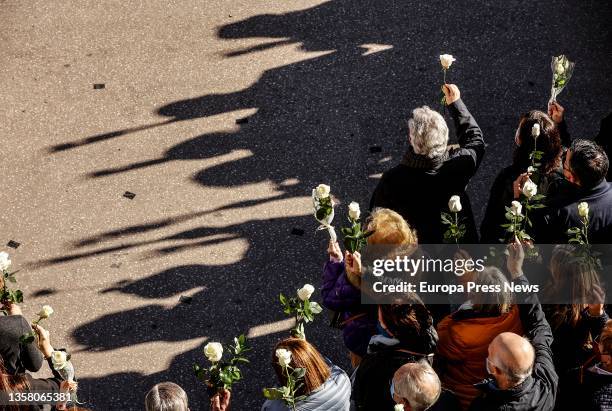 Crowd holds white flowers at a rally and minute of silence in memory of Cristina, a woman victim of gender violence, in the Plaza del Ayuntamiento,...