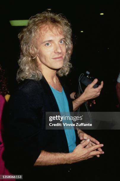 British singer, songwriter and guitarist Peter Frampton wearing a turquoise t-shirt beneath a black jacket, circa 1985.