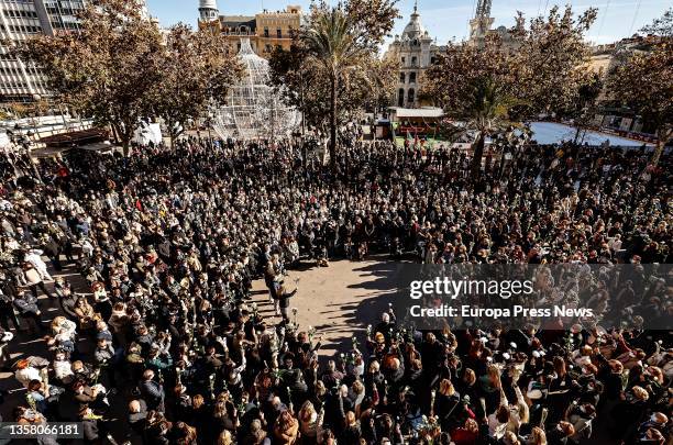 Crowd holds white flowers at a rally and minute of silence in memory of Cristina, a woman victim of gender violence, in the Plaza del Ayuntamiento,...