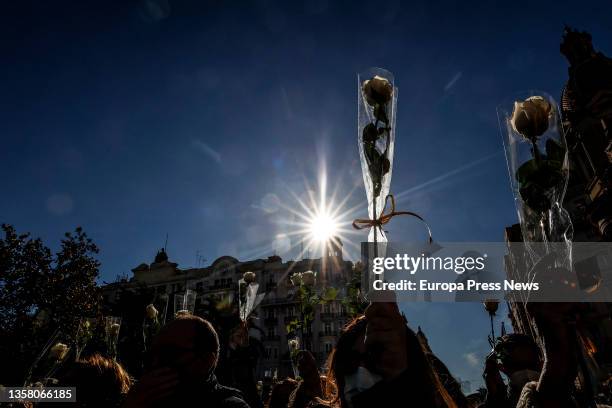 Crowd holds white flowers at a rally and minute of silence in memory of Cristina, a woman victim of gender violence, in the Plaza del Ayuntamiento,...